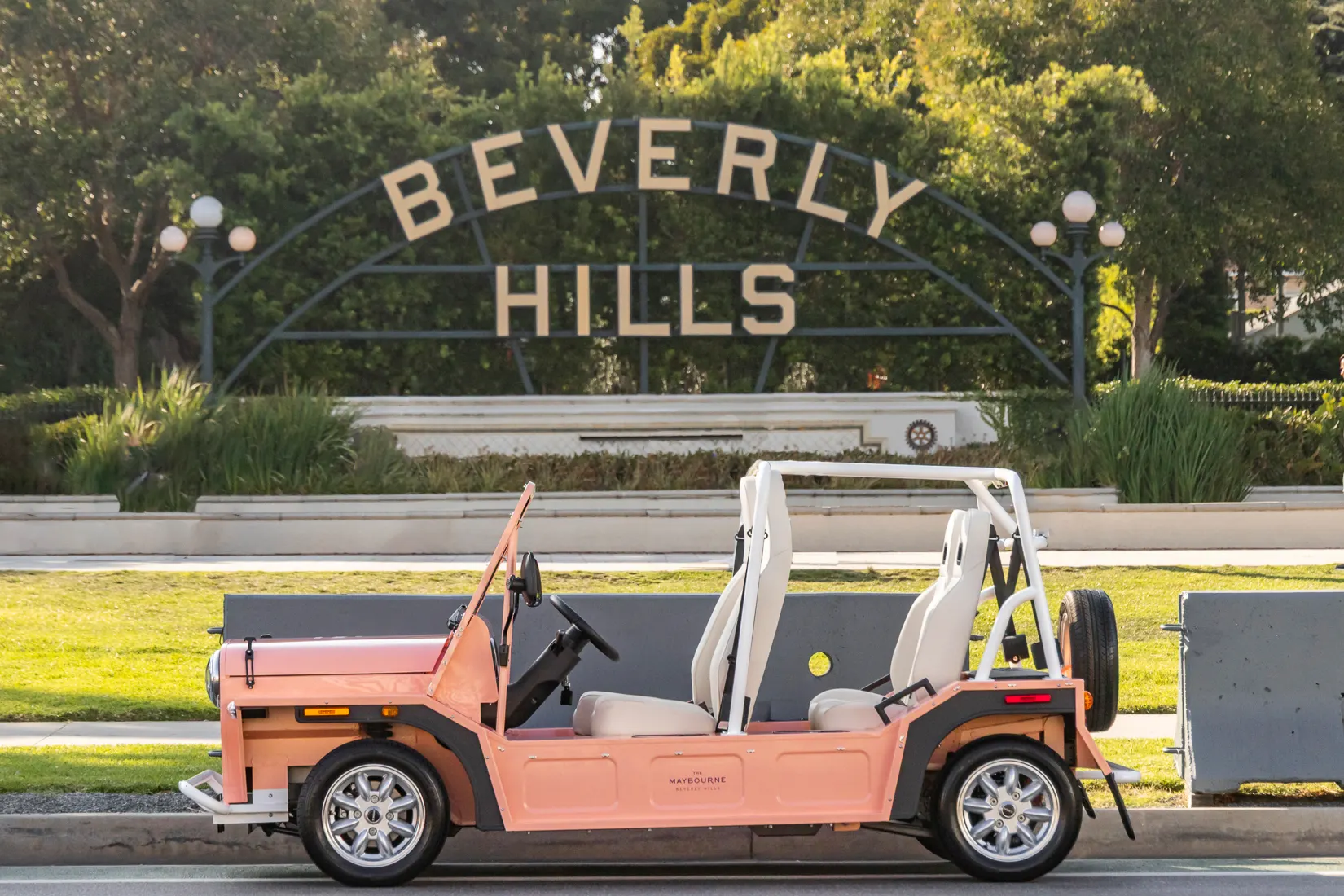 A Moke parked in profile beside the Beverly Hills sign