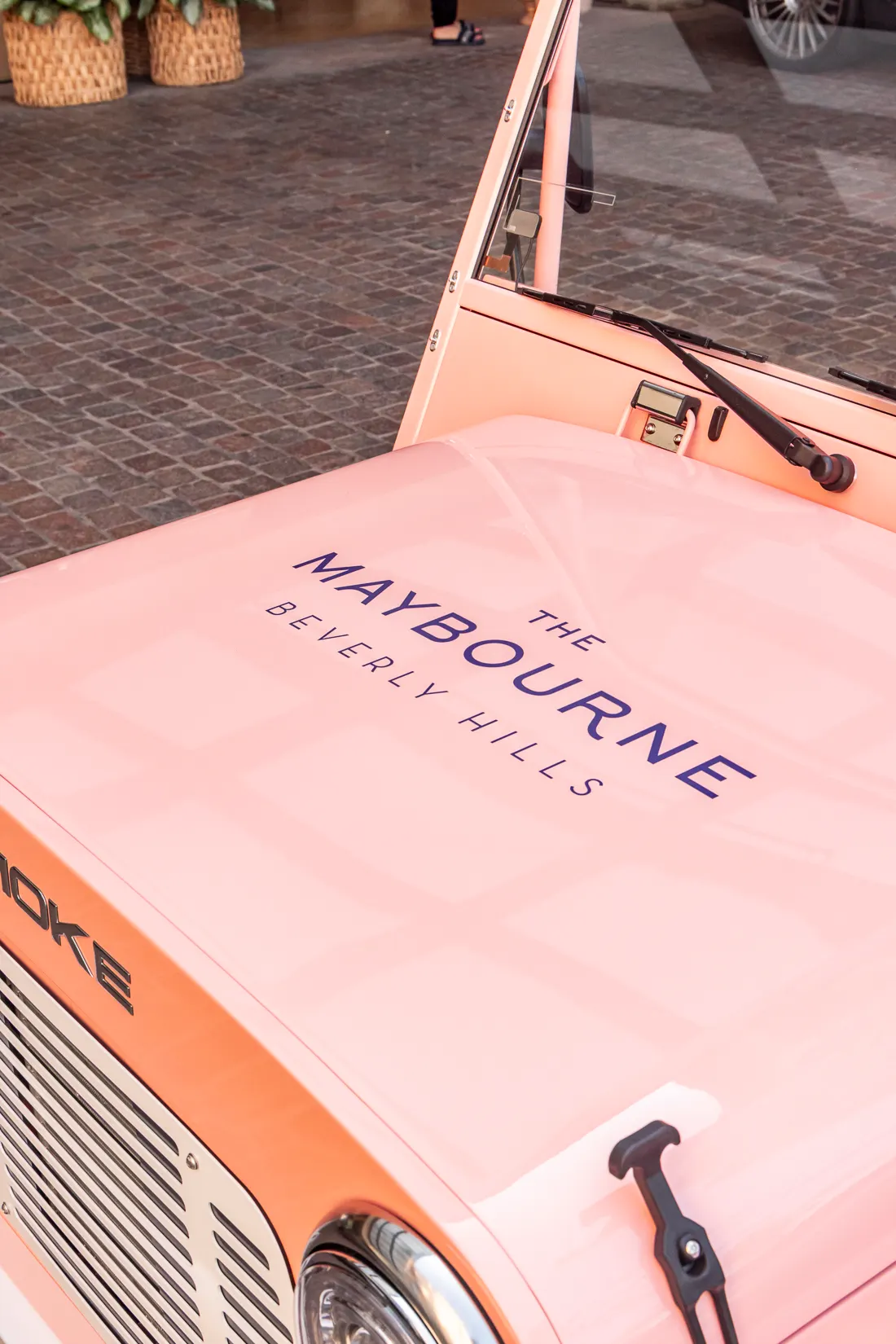 The Maybourne Beverly Hills wordmark on Maybel's pink hood
