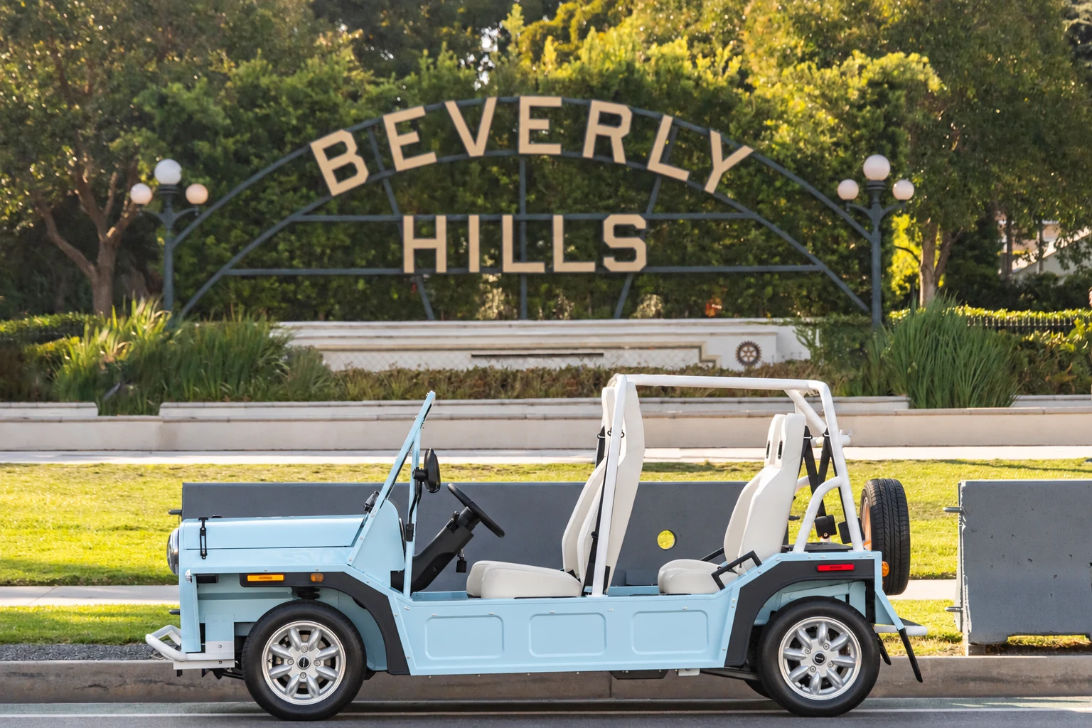 A Wave Blue Moke parked in front of the Beverly Hills sign