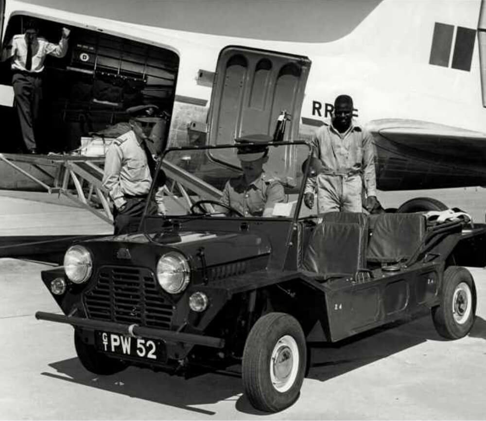 A military Mini Moke parked on the tarmac next to a Royal Air Force aircraft, 1960s