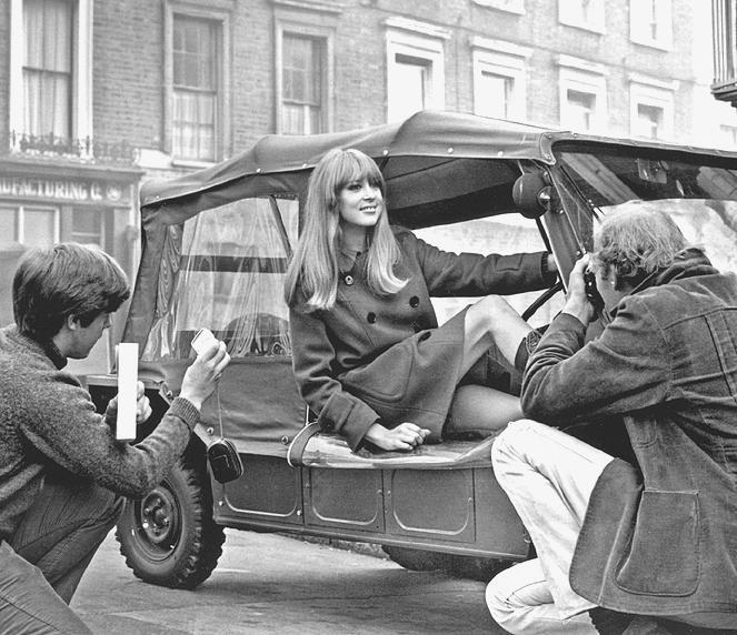 A fashion model poses on a Mini Moke during a 1960s photo shoot on a London street